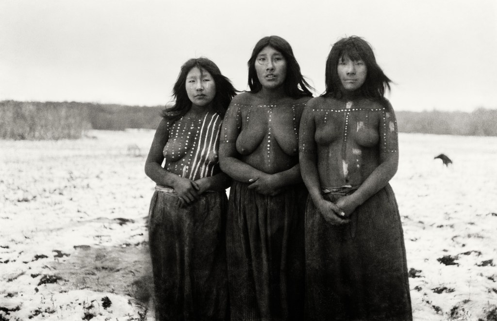 Desfile del Kewánix, rito selknam. Elek, Angela Loij e Imshuta durante una danza llamada Kewánix en honor a Tanu. Cada mujer tiene el cuerpo pintado con arcilla roja y motivos blancos específicos de su linaje. © Martin Gusinde / AnthroposInstitut / Éditions Xavier Barral.